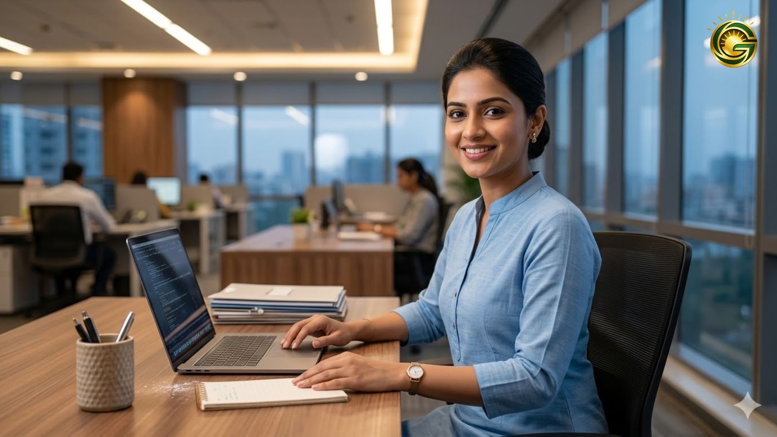 A professional working woman posing in a modern office wearing a stylish light blue straight-cut kurti with minimal jewelry.